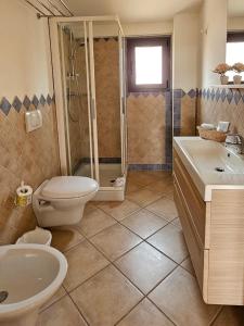 a bathroom with a shower and a toilet and a sink at Emerald Coast Hotel in Olbia