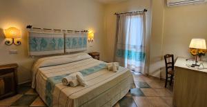 a bedroom with a bed with towels on it at Emerald Coast Hotel in Olbia