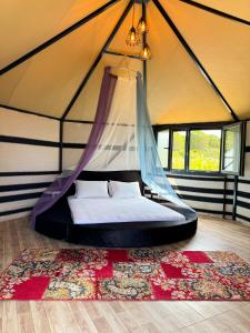 - une chambre avec un lit dans une tente dans l'établissement Le Petit Hotel ve Bağ Evi, à Bozcaada
