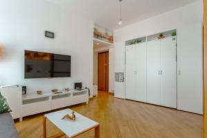 ein Wohnzimmer mit weißen Schränken und einem Tisch in der Unterkunft ELI APARTMENT in Rom