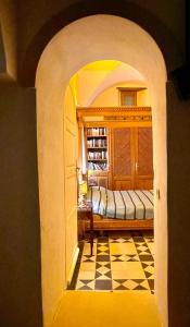 um arco que leva a um quarto com uma cama em Dar Aziz em Sousse