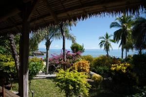 a view of the beach from a resort with palm trees and flowers at Nosy komba villa tsaratora in Anjiabe +12 photos
