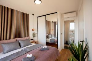 una camera da letto con un letto e un grande specchio di Seaside residence - Sunrise appartment a Kožino