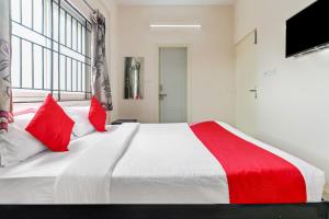 a bedroom with a large white bed with red pillows at 49996 JJ Comforts in Bangalore