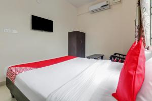 um quarto com uma cama branca e um cobertor vermelho em 49996 JJ Comforts em Bangalore