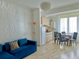 ein Wohnzimmer mit einem blauen Sofa und einem Tisch in der Unterkunft Blue Summerland Apartments in Mamaia