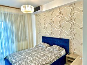 ein Schlafzimmer mit einem blauen Bett mit einer Wand in der Unterkunft Blue Summerland Apartments in Mamaia