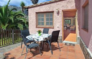 una mesa y sillas en el patio de una casa en Nice Home In Buenavista Del Norte, en Buenavista del Norte