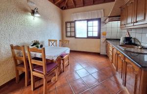 Una cocina con una mesa y sillas y un fregadero. en Nice Home In Buenavista Del Norte, en Buenavista del Norte