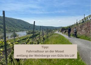 two people riding bikes down a road with a sign at Relax Apartment - für Familien, stadtnah, mit Parkplatz in Koblenz