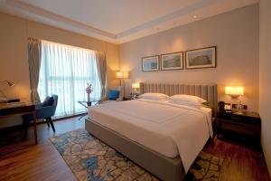 a hotel room with a large bed and a desk and a piano at Taj Bangalore in Devanahalli-Bangalore