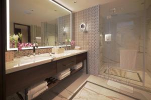 a bathroom with a large sink and a shower at Taj Bangalore in Devanahalli-Bangalore