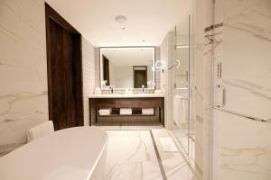 a bathroom with a toilet and a sink and a mirror at Taj Bangalore in Devanahalli-Bangalore