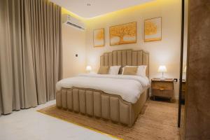 ein Schlafzimmer mit einem großen Bett mit weißer Bettwäsche und Kissen in der Unterkunft شقة بصالة وغرفة نوم ودخول ذاتي 8B in Riad