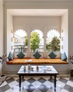 uma sala de estar com um banco em frente a uma janela em Chandra Vilas Heritage stay em Udaipur