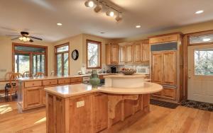 a kitchen with wooden cabinets and a large island at Mountain Memories - Viking gas range GE double ovenwarmer Lake views in Marblehill