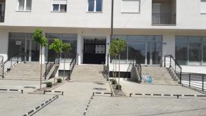 普里什蒂納的住宿－Apartment Beerti，前方设有玻璃门和楼梯的建筑