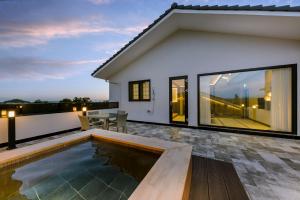a house with a swimming pool and a patio at Hotel HaruSida in Seogwipo