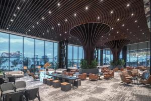 a lobby with chairs and tables and windows at Grand Sapphire Resort & Casino in Yeni Iskele
