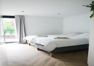 een slaapkamer met een bed en een groot raam bij Stijlvol ingerichte (4 pers.) bungalow in Baarland in Baarland