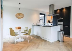 een keuken en eetkamer met een tafel en stoelen bij Stijlvol ingerichte (4 pers.) bungalow in Baarland in Baarland