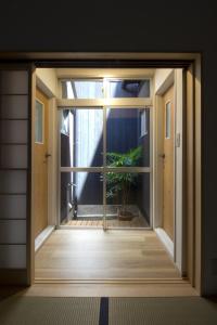 uma porta aberta com um vaso de plantas num quarto em Gion House em Quioto