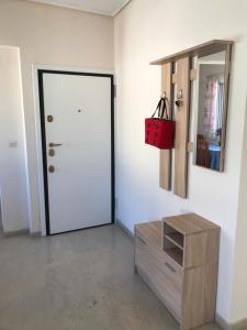 a room with a door and a dresser and a red bag at Loutraki Vacation in Loutraki