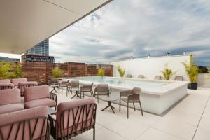 a rooftop patio with a pool and chairs at VISIONAPARTMENTS Basel Nauenstrasse - contactless check-in in Basel