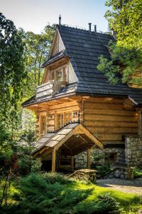 une grande maison en bois avec un toit en gambrel dans l'établissement Dom Crocus, à Zakopane