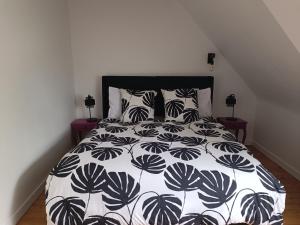 a bedroom with a bed with a black and white comforter at Vue unique sur le Mont St Michel in Huisnes-sur-Mer