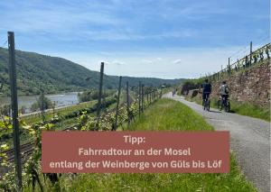 two people riding bikes down a road with a sign at New York Apartment - für Freunde & Familien, stadtnah, Parkplatz, E-Ladestation, Gitterbox für Fahrräder, Fitnessstudio, digitale Gästemappe mit Restaurant- und Unternehmenstipps in Koblenz