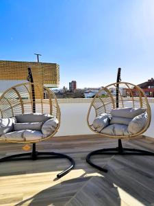 2 chaises en osier assises au-dessus d'un toit dans l'établissement Pont de Fusta Apartments, à Valence