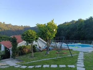 uma casa com um parque infantil com um baloiço em Quinta da avó Miquinhas em Vieira do Minho
