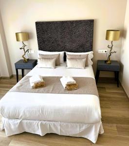 1 dormitorio con 1 cama blanca grande y 2 mesitas de noche en Pont de Fusta Apartments, en Valencia