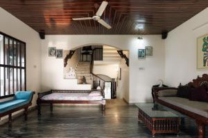 a living room with a ceiling fan and a couch at The Coastal Relic by EWA Properties in Padubidri
