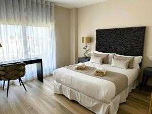 a bedroom with a large bed with a desk and a bed sidx sidx sidx at Pont de Fusta Apartments in Valencia