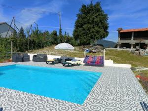 uma piscina num quintal com cadeiras e uma casa em Quinta da avó Miquinhas em Vieira do Minho