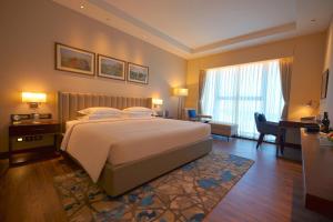 a bedroom with a large bed and a desk at Taj Bangalore in Devanahalli-Bangalore
