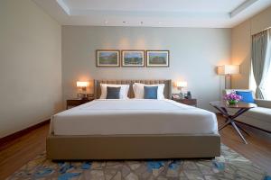 a bedroom with a large white bed and a couch at Taj Bangalore in Devanahalli-Bangalore