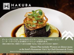un plato blanco con un plato con comida. en THE HAPPO by Hakuba Hospitality Group en Hakuba