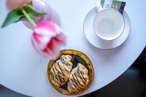 a table with a bowl of cookies and a plate and a flower at Aparthotel Strefa Premium in Tychy