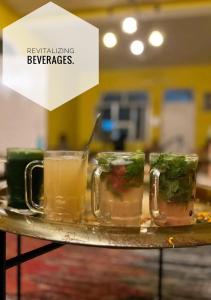 una bandeja con cuatro tazas de bebidas en una mesa en Art Bliss Hostel, en Rishīkesh