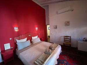 Dormitorio rojo con cama blanca y pared roja en La Guzmana de Ronda, en Ronda