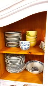 uma prateleira com pratos e tigelas num armário em Five maple home for families and wild nature lovers em Měděnec