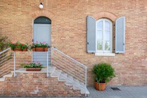 a brick building with stairs and two windows at Mery's House in Montepulciano