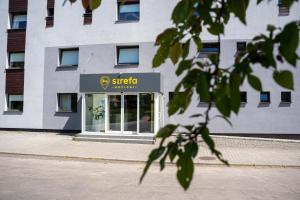 a building with a sign on the front of it at Aparthotel Strefa Premium in Tychy
