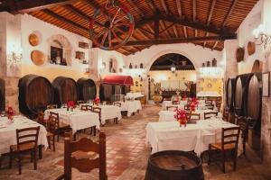 a restaurant with white tables and chairs and wine barrels at Hotel Villa Giulia in Marzamemi