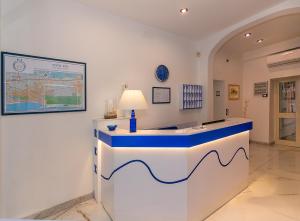 a lobby with a blue and white reception desk at Hotel Rex in Viareggio
