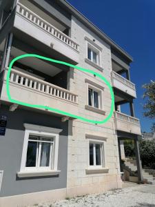 budynek z zielonym okręgiem na boku w obiekcie Apartments Dinko w Duće