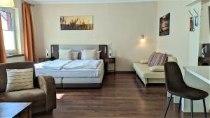 um quarto de hotel com uma cama e um sofá em Altstadthotel Goldene Kugel em Waren